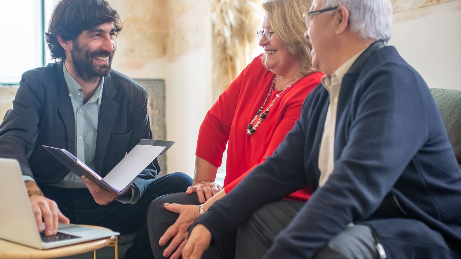 Adviseur bespreekt het testament en de nalatenschap met een ouder echtpaar aan een bureau